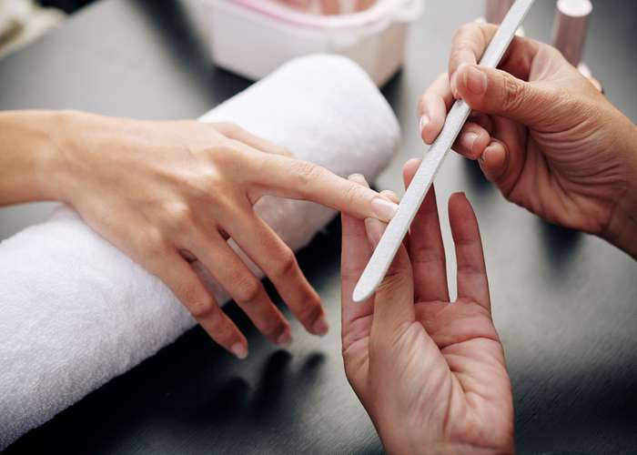 Nailcare: woman taking care of her nails to improve nails health and keep them looking good.