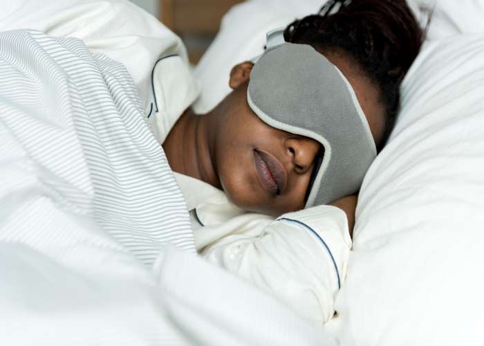 Sleep well for IBD: woman sleeping in bed.
