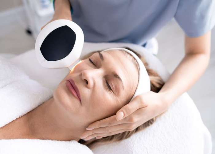 Woman doing laser therapy to improve skin health and fight skin aging: laser for skin anti-aging.