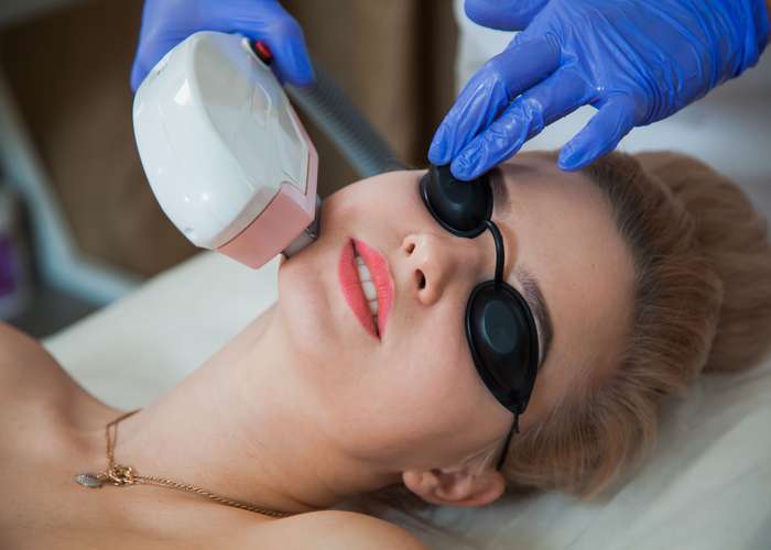 Woman doing laser therapy session for skin pigmentation.