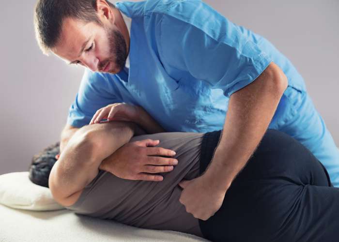Chiropractic use, benefits, and precautions. Chiropractor adjusting and manipulating the spine of a patient.