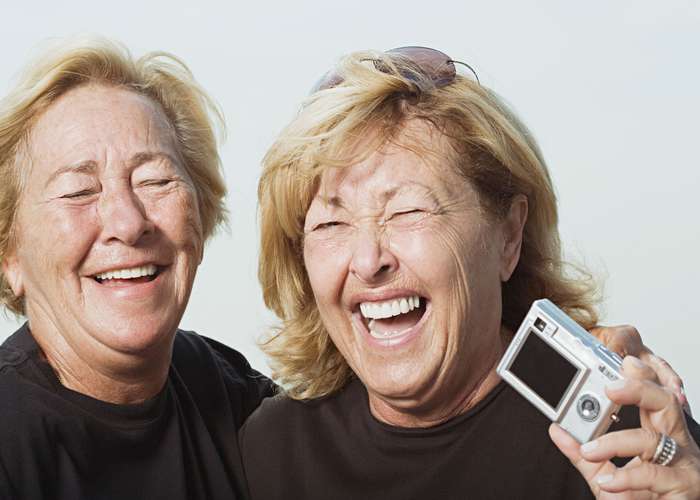 Laughter therapy: two women laughing hard doing a session of laughter therapy.