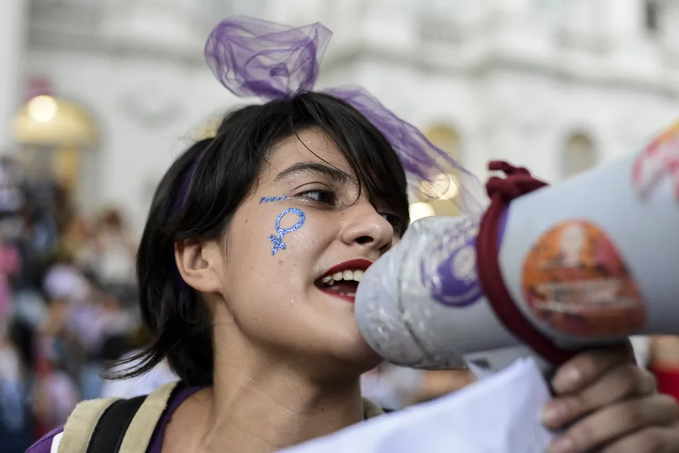Mulher protesta com megafone contra machismo violência de gênero feminicídio e pede por igualdade em Marcha das Mulheres em Curitiba em 8 de março de 2019 Foto Henry Milleo Getty Images