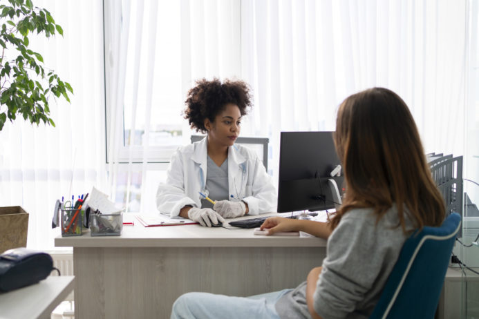 mulher sendo atendida num consultorio medico foto freepik