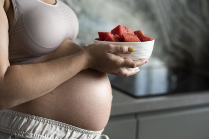 close-up-pregnant-woman-with-fruit-bowl-freepik