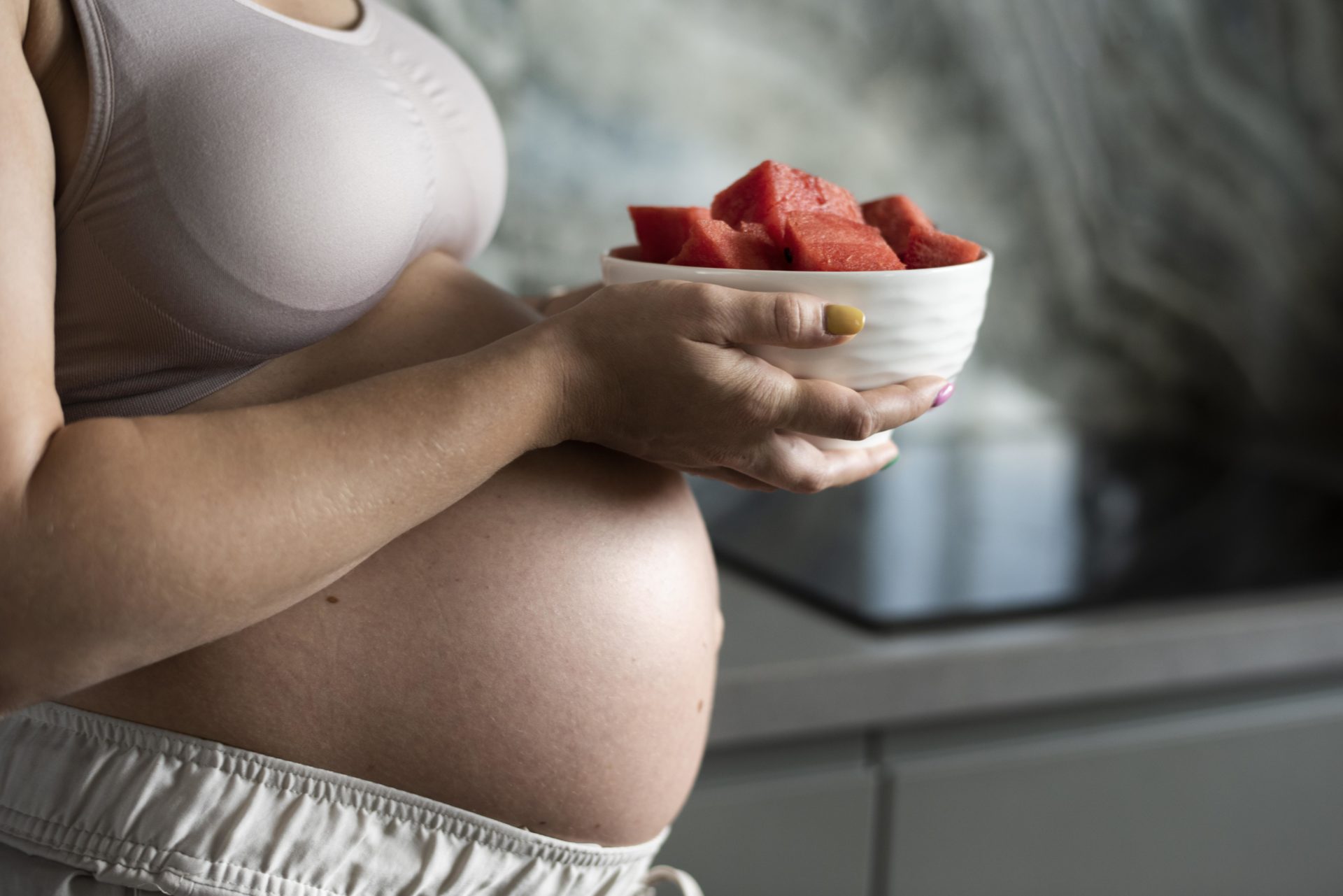 close-up-pregnant-woman-with-fruit-bowl-freepik
