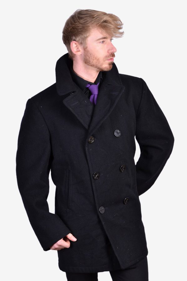 Vintage Sterlingwear Of Boston pea coat oat in a black colour. Double breasted six anchor button front. Twin waist pockets, mid vent reverse and classic sailor collar. Made from a wool fabric and fully inside lined. Label reads 44R.