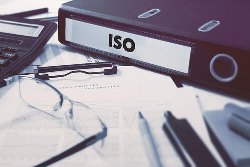 Office folder with inscription ISO - International Organization for Standardization - on Office Desktop with Office Supplies. Business Concept on Blurred Background.