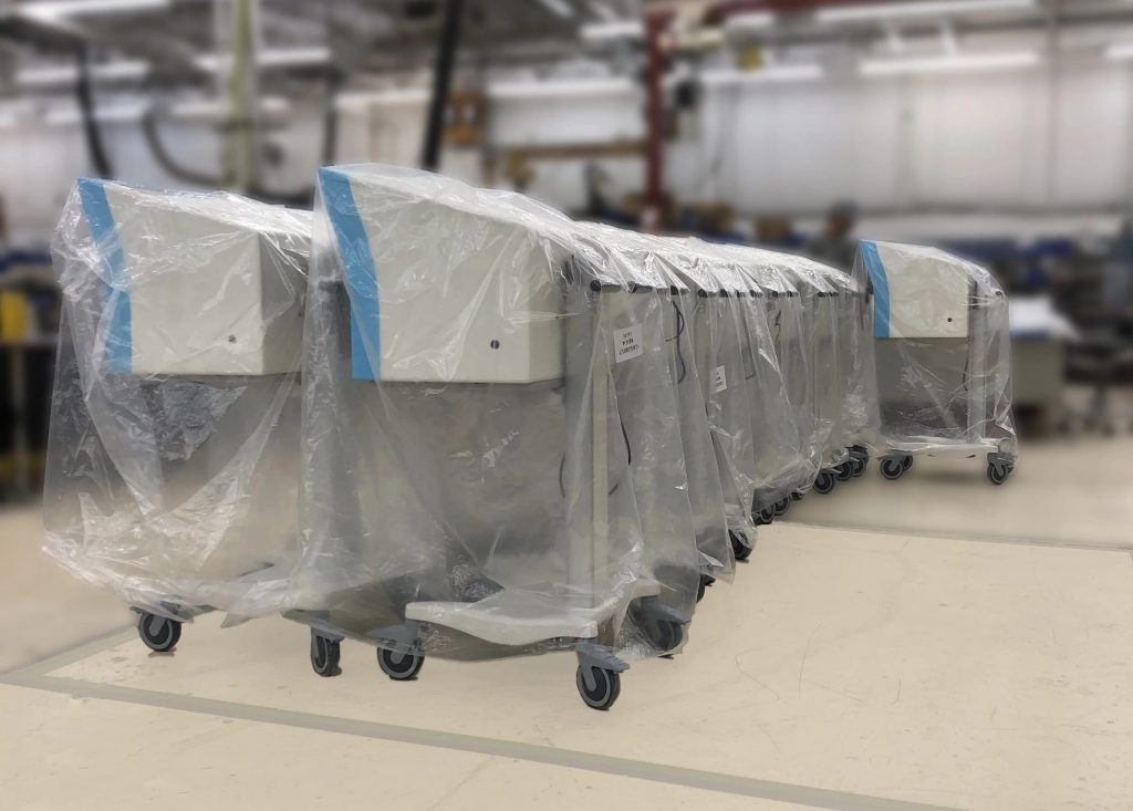 Medical Devices on wheels covered in plastic, ready for shipment. 