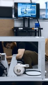 Assembler looking at a machine's base with design's work instructions on-screen