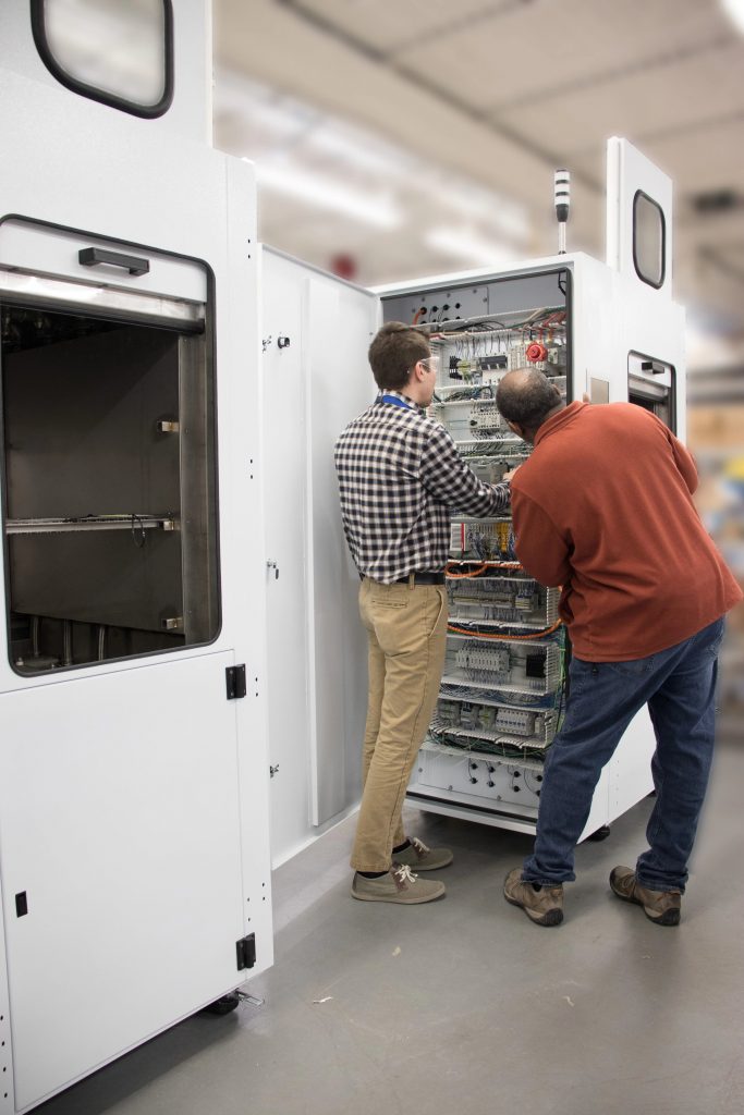 two npi manufacturing engineers at an alpha machine build