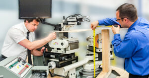 Engineers measuring and reviewing prototype hardware during product development