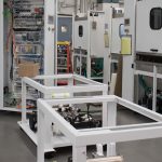 Technician assembling electrical controls on large white industrial equipment