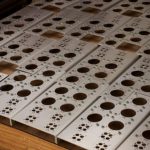 Sheet metal panels with dense hole patterns and large circular cutouts produced through CNC turret punching.