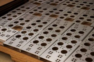 Sheet metal panels with dense hole patterns and large circular cutouts produced through CNC turret punching.