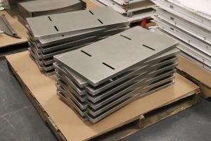Stacked sheet metal panels with repeatable slots and precision features produced through sheet metal punching.