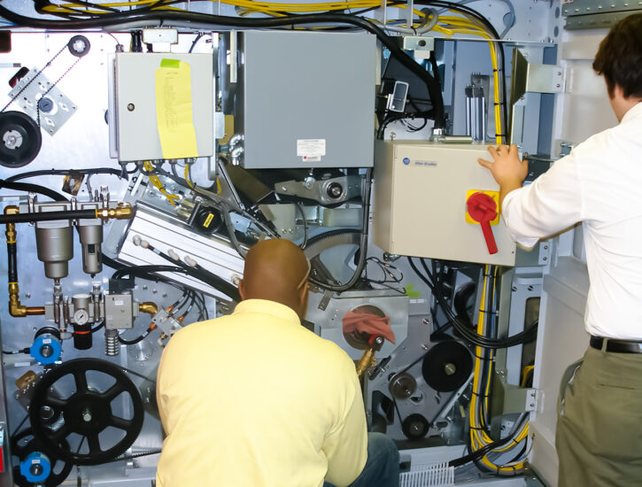 Engineers work together on a machine, integrating custom automation equipment in PEKO's dynamic new product introduction area.