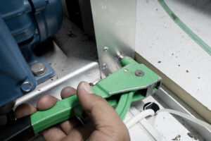 Manual sheet metal riveting tool being used to connect plate cover