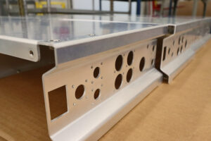 Aluminum panel component with laser-cut holes and formed flanges