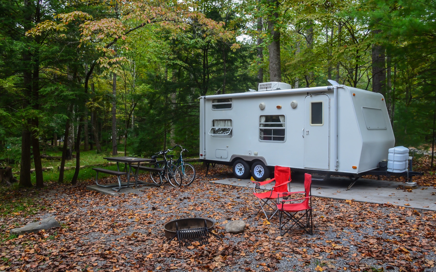Camp trailer set up in campground site with bicycles