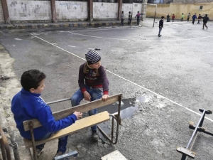 Varios niños en el patio de la escuela "Ibn Hazm al Andalusi", en el barrio barrio Saladino de Alepo. EFE