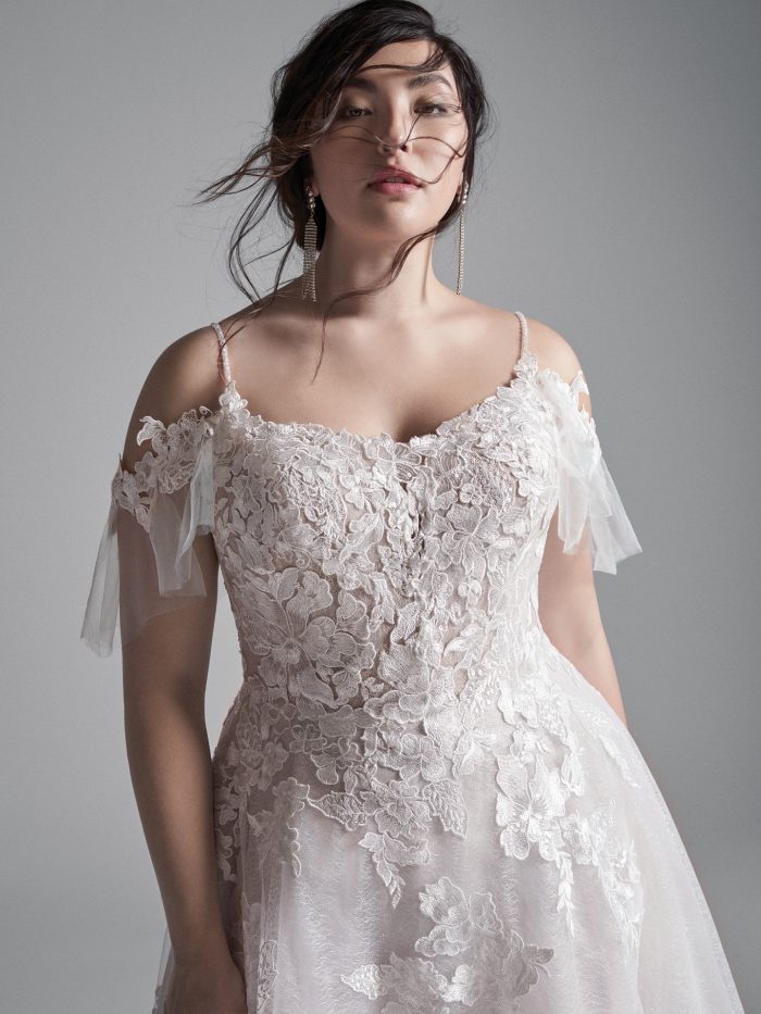 Plus Size Model Wearing Plus Size Cold Shoulder Floral Lace A-line Wedding Gown Called Houston by Sottero and Midgley