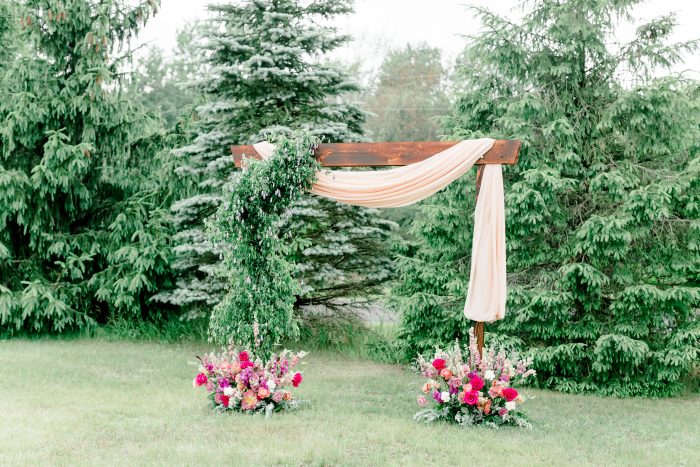 European Rustic Bohemian Wedding Arch in Green Field with Pine Trees