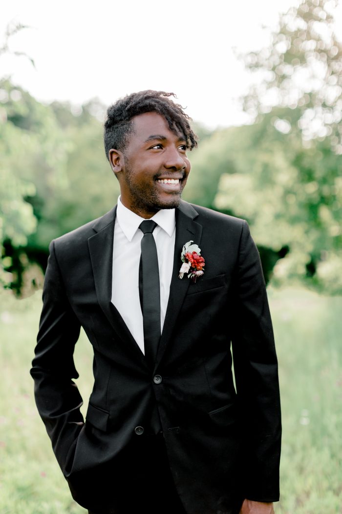 Black Groom Wearing Black Suit and Black Tie with Jewel Tone Boutonniere