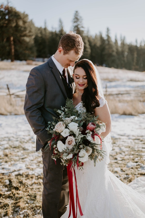 Real Bride Wearing Wedding Dress by Maggie Sottero holding bouquet of roses