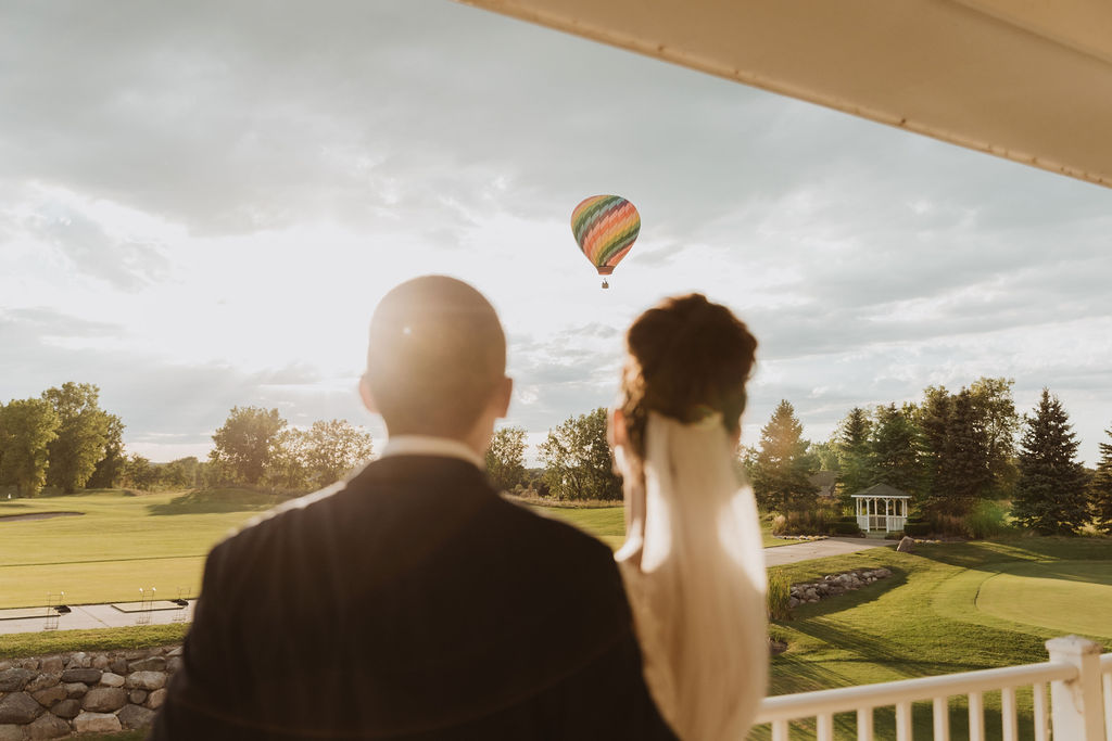 Bride and Groom Looking at Hot Air Balloon at Real Wedding