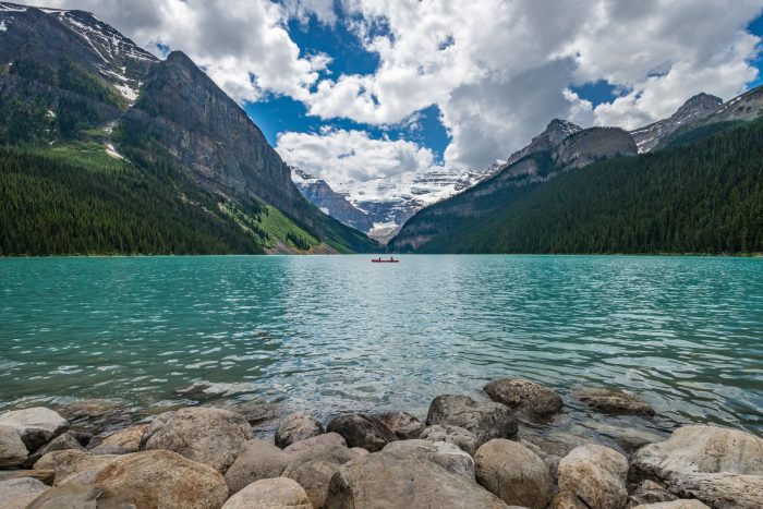 View of Lake Louise in Canada with White Clouds and Crystal Clear Water