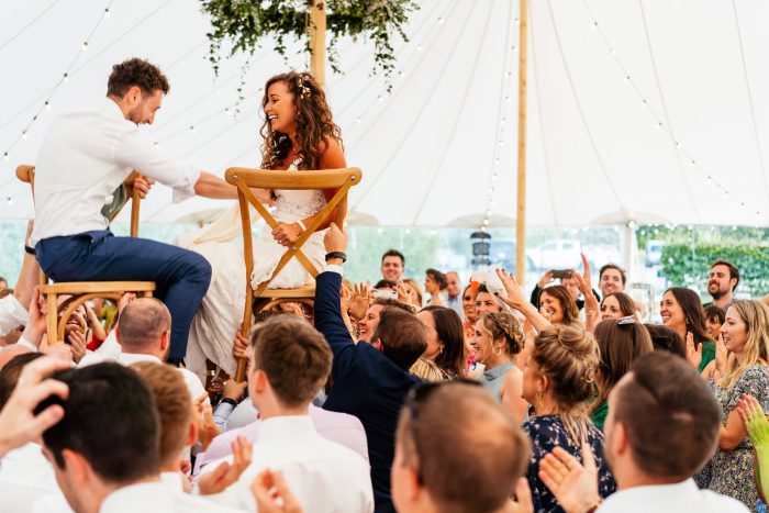 Bride and Groom Getting Lifted Up in Chairs During Jewish Wedding for Horah Circle