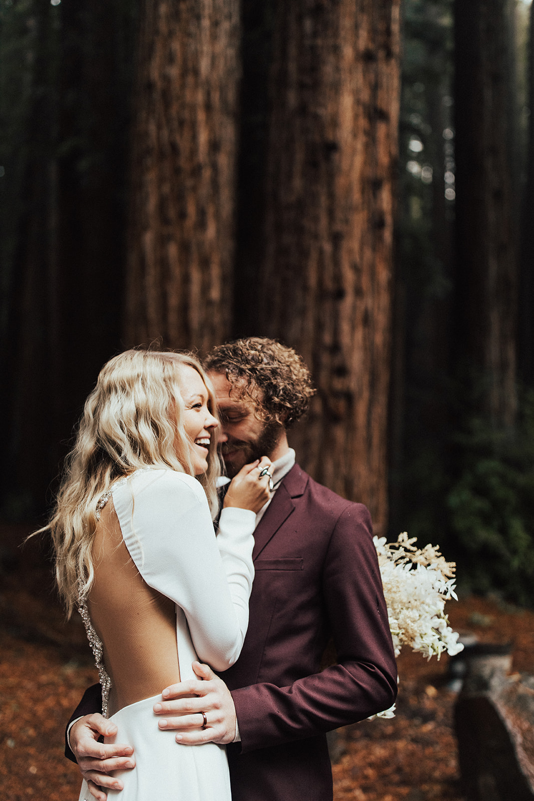 Groom in the Red Woods with Real Bride Wearing Illusion Back Crepe Sheath Wedding Dress Called Arleigh by Sottero and Midgley