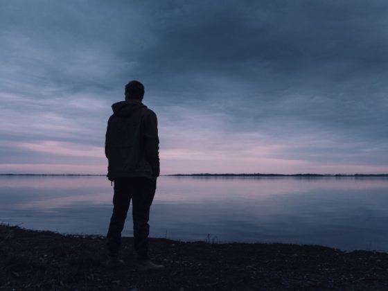 person standing near lake