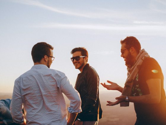three men standing while laughing