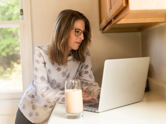 woman using gray laptop computer in kitchen