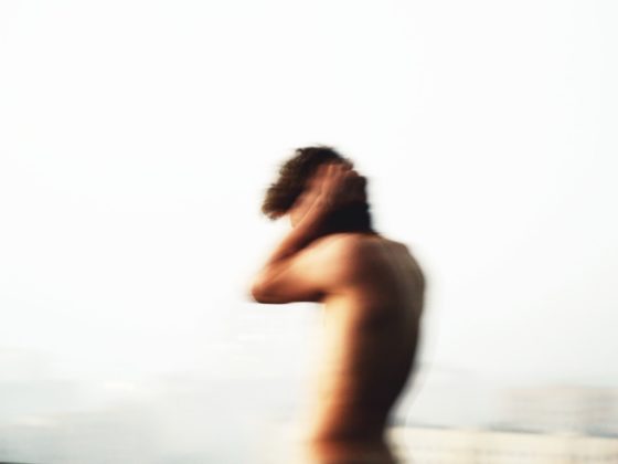 topless woman standing on beach during daytime
