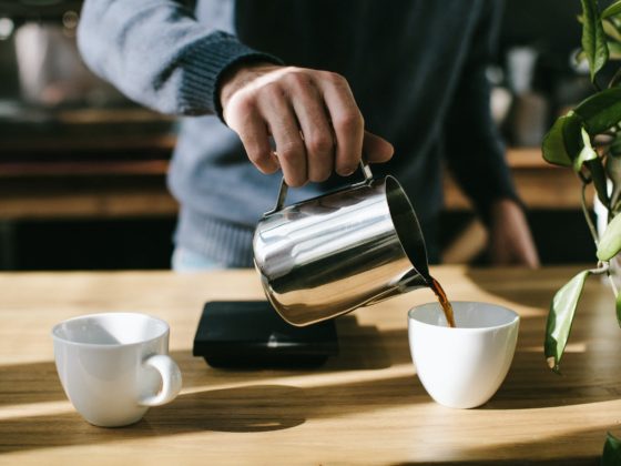person pouring coffee in white ceramic mug