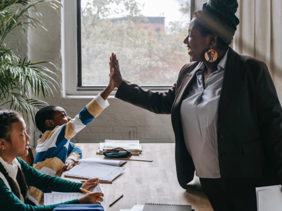 cheerful black teacher with diverse schoolkids