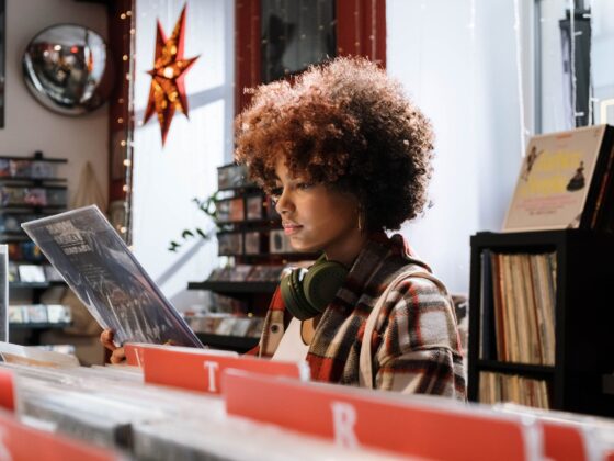 woman in red and white plaid shirt checking the vinyl record