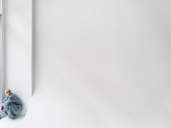 lonely patient embracing knees in light clinic