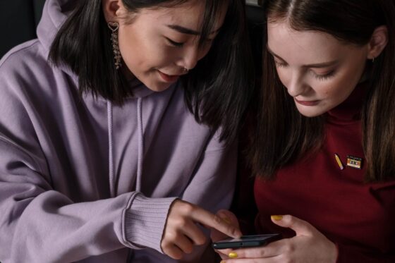 close up shot of two teenagers looking at a smartphone