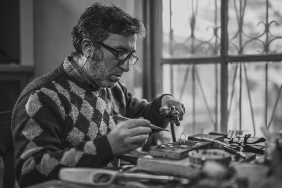 grayscale photo of man holding tools