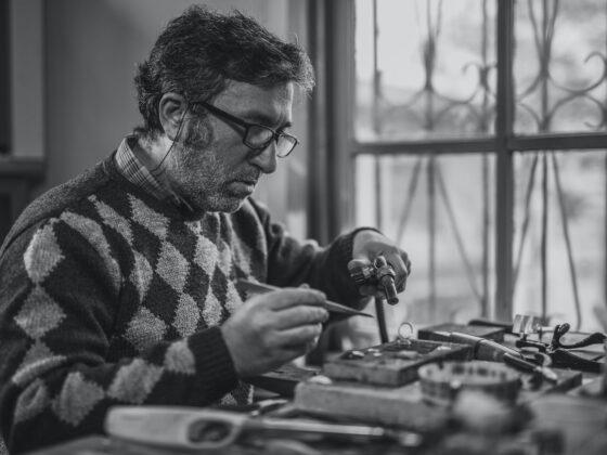 grayscale photo of man holding tools