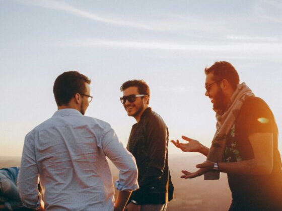 three men standing while laughing