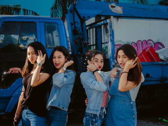 young women in casual wear standing in front of a truck
