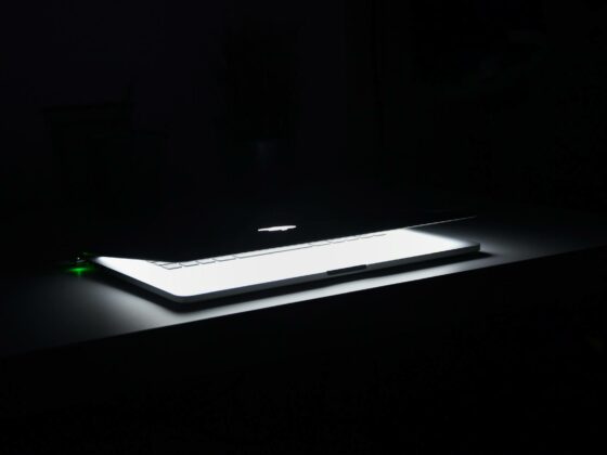 photography of macbook half opened on white wooden surface