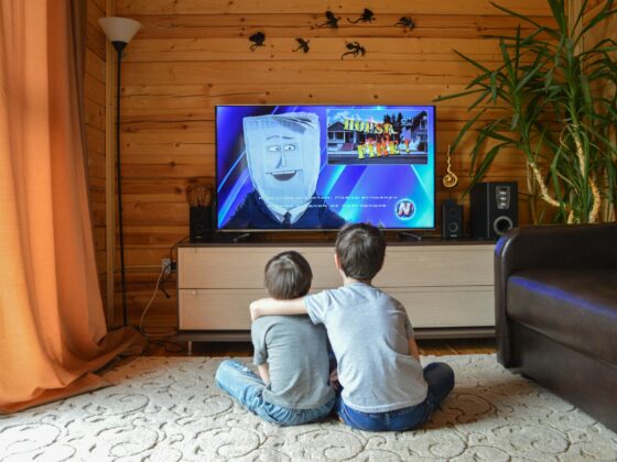 anonymous siblings cuddling and watching tv at home